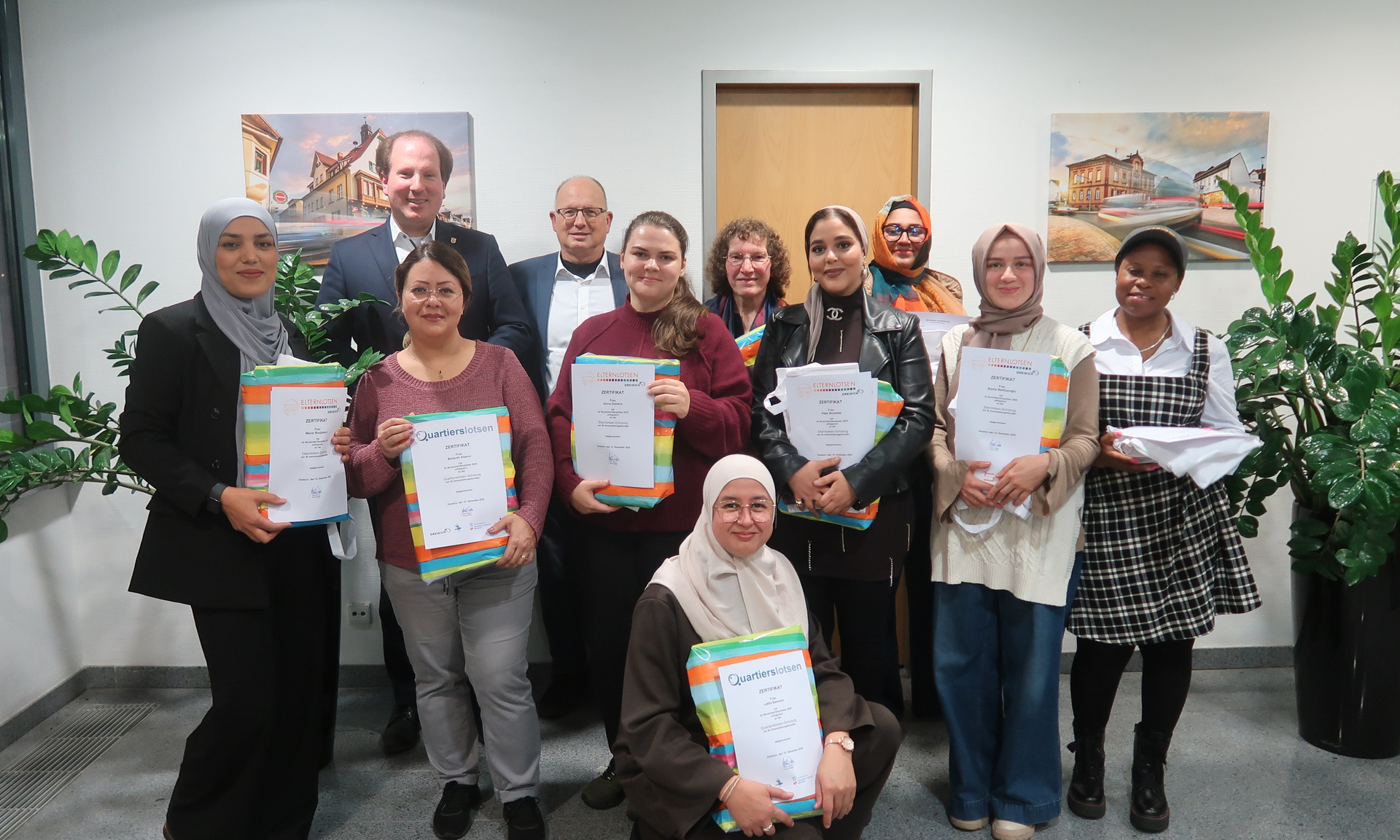 Das Foto zeigt eine Gruppe stolzer Quartiers-Lotsen, die ihr Zertifikat stolz in den Händen halten.