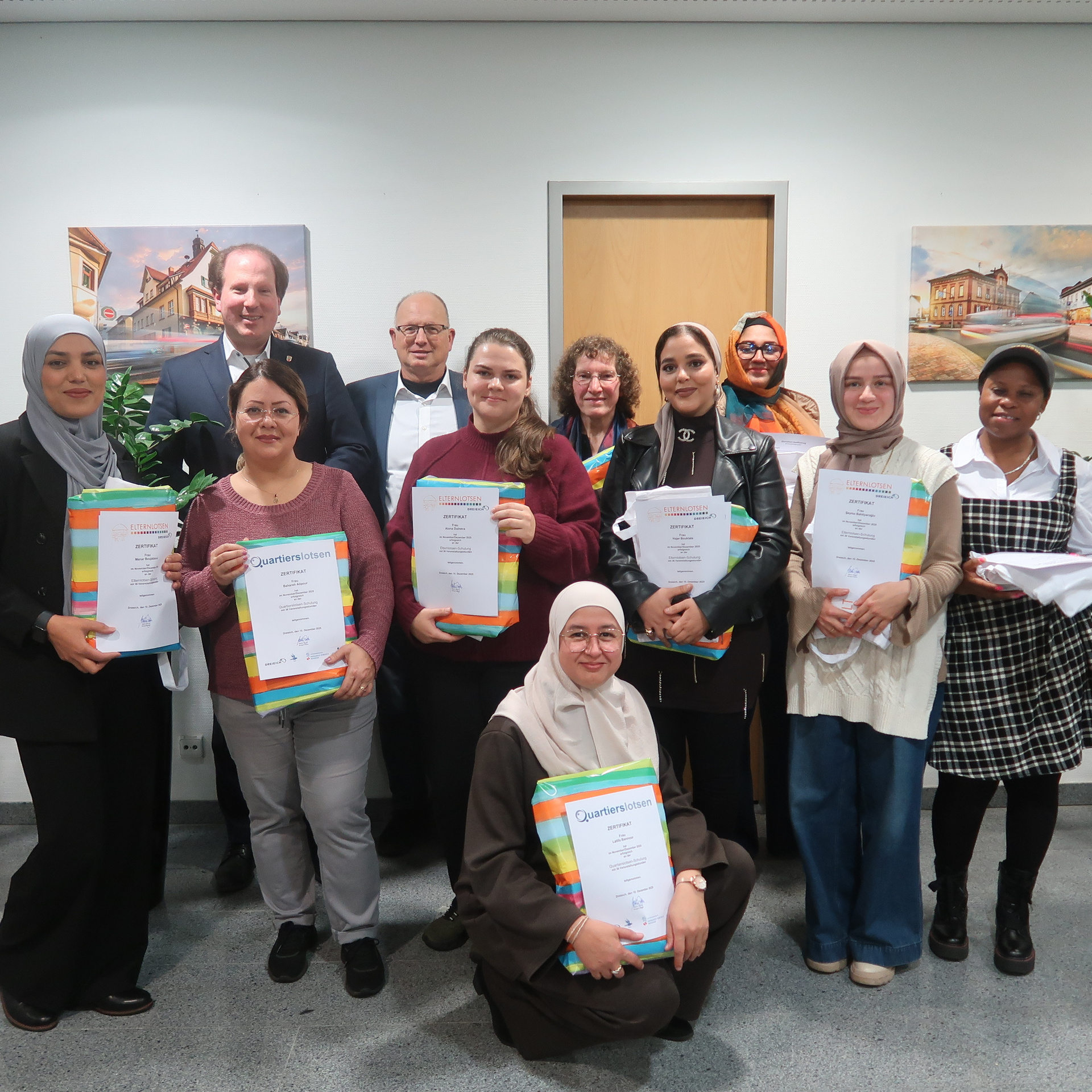 Das Foto zeigt eine Gruppe stolzer Quartiers-Lotsen, die ihr Zertifikat stolz in den Händen halten.