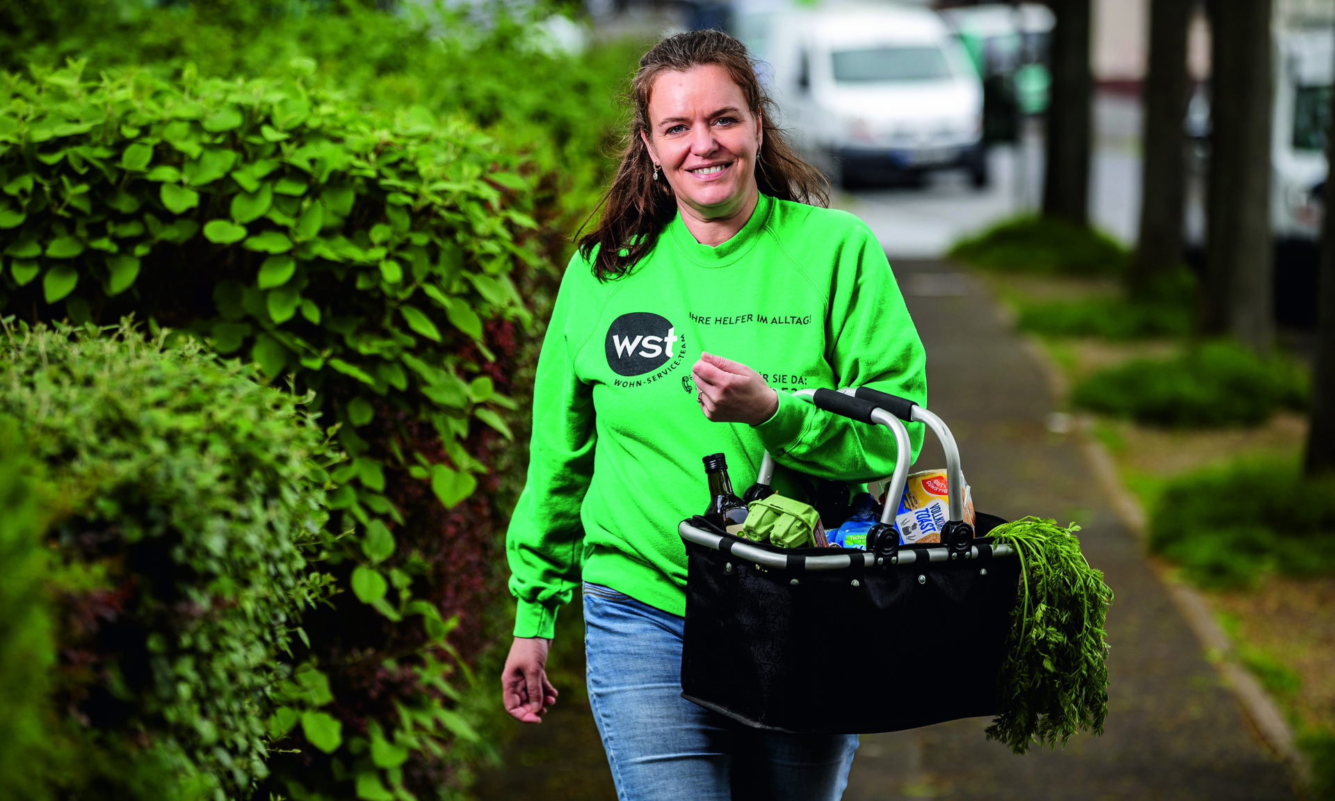 WST-Teammitglieder bei der Arbeit mit Einkaufskorb in der Hand