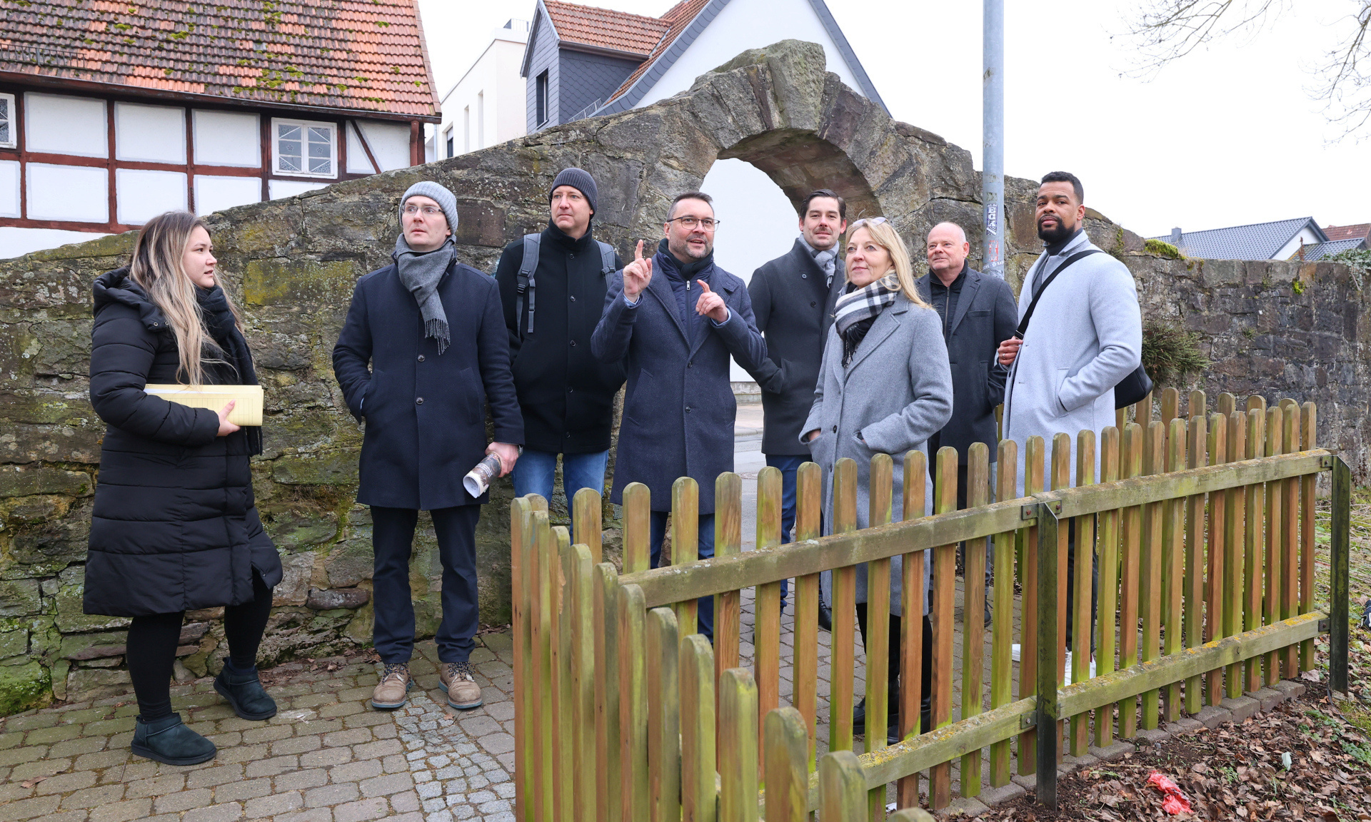 Eine Gruppe von acht Menschen im Freien, vor einer alten Steinmauer, u.a. Torben Busse, Bürgermeister von Hofgeismar, Karin Jasch vom Hessischen Wirtschaftsministerium sowie Ulrich Türk und Marvin Coker von der ProjektStadt.