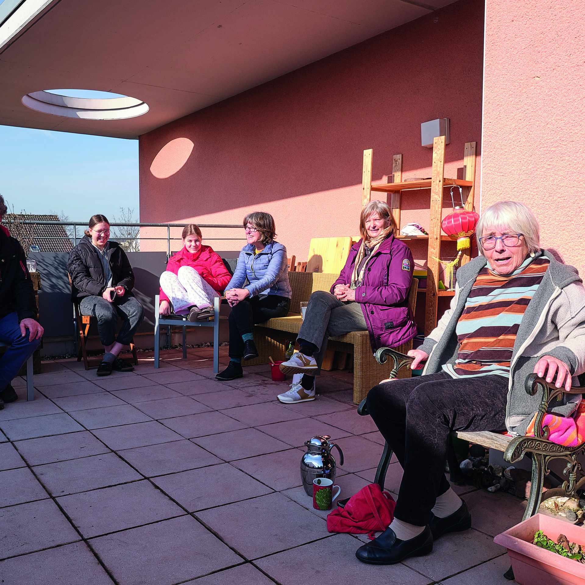 Gruppe von Personen sitzt auf einer Terrasse