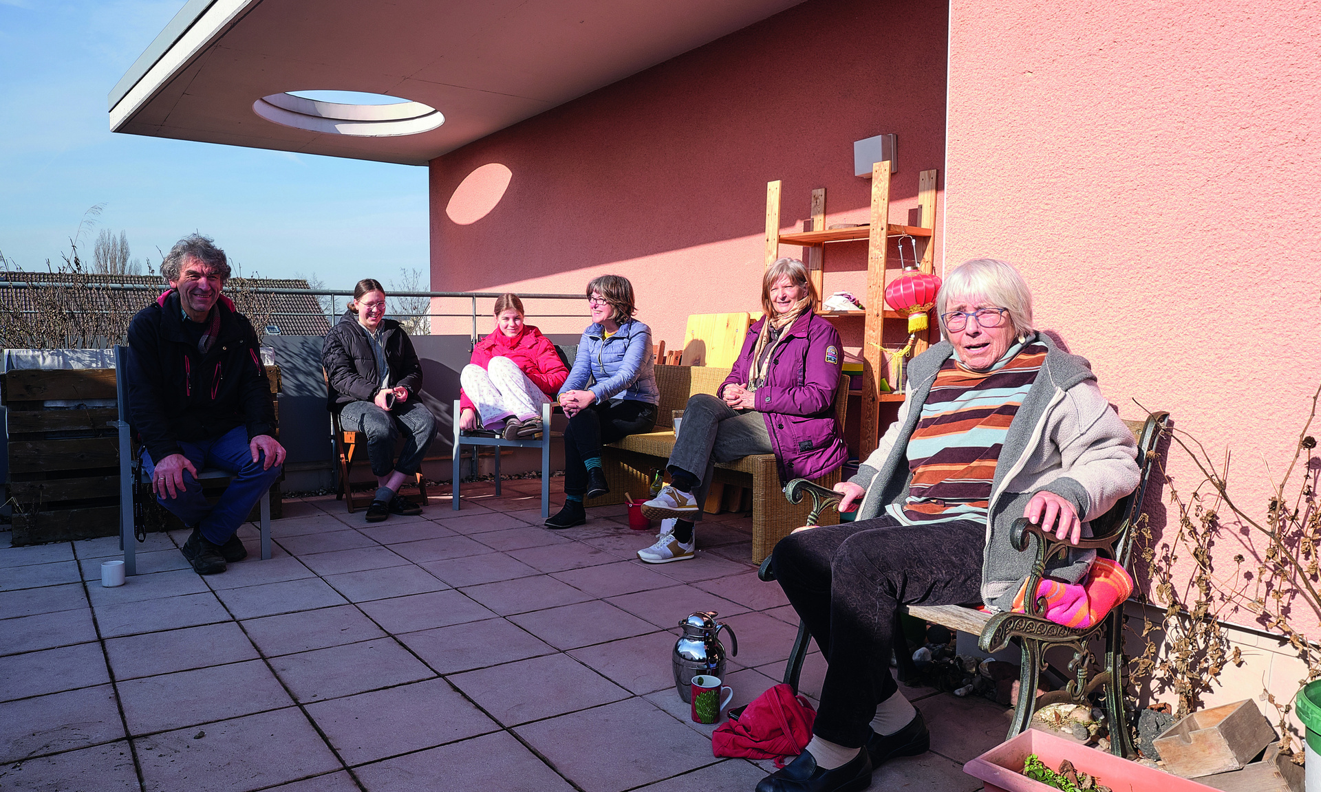 Gruppe von Personen sitzt auf einer Terrasse