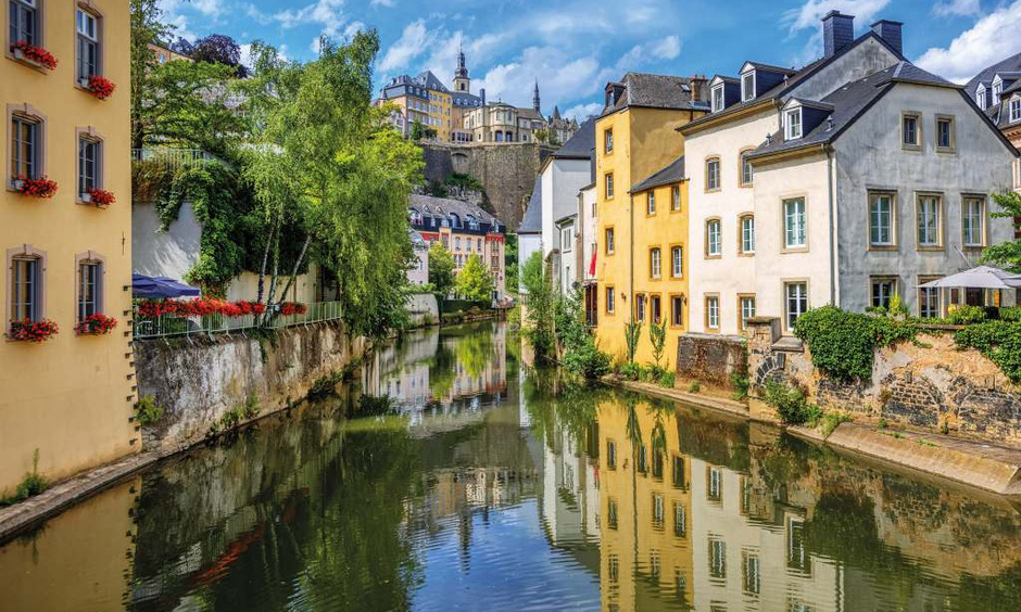 Fluss führt zwischen Häusern in Luxemburg durch