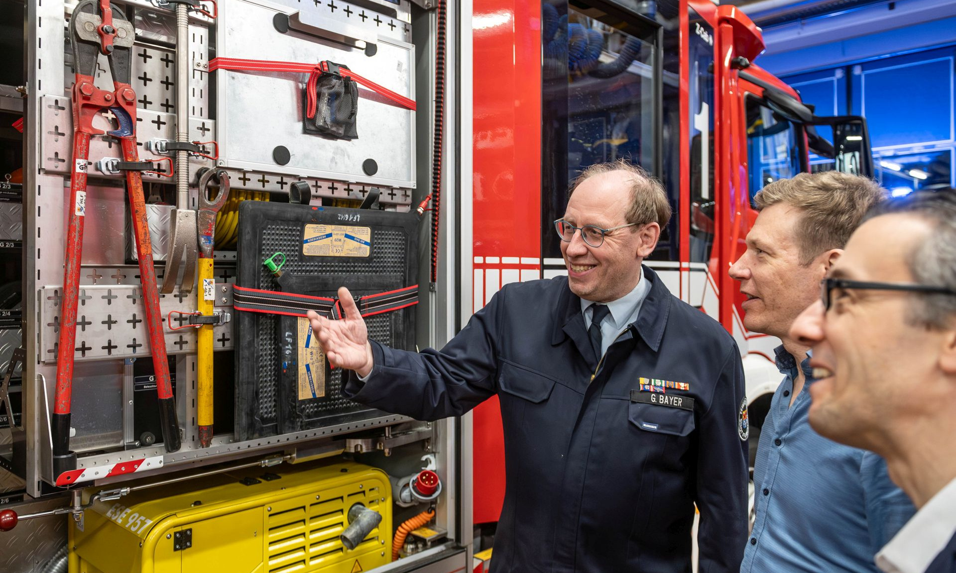 Im Anschluss an die offizielle Übergabe erläuterte Stadtbrandinspektor Gerhard Bayer wichtigsten Ausrüstungsgegenstände der Feuerwehr beim Brandeinsatz. Foto: NHW/Strohfeldt