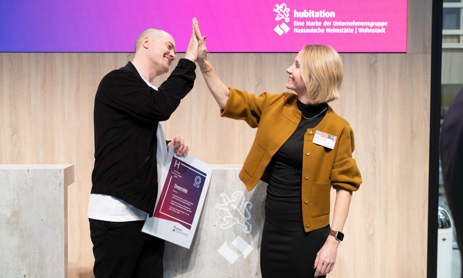 Pia Hesselschwerdt (Volkswohnung Karlsruhe) und Moritz Lohmann (Swarmlab GmbH Berlin) freuen sich über ihren Erfolg bei den hubitation finals und geben sich High Five.