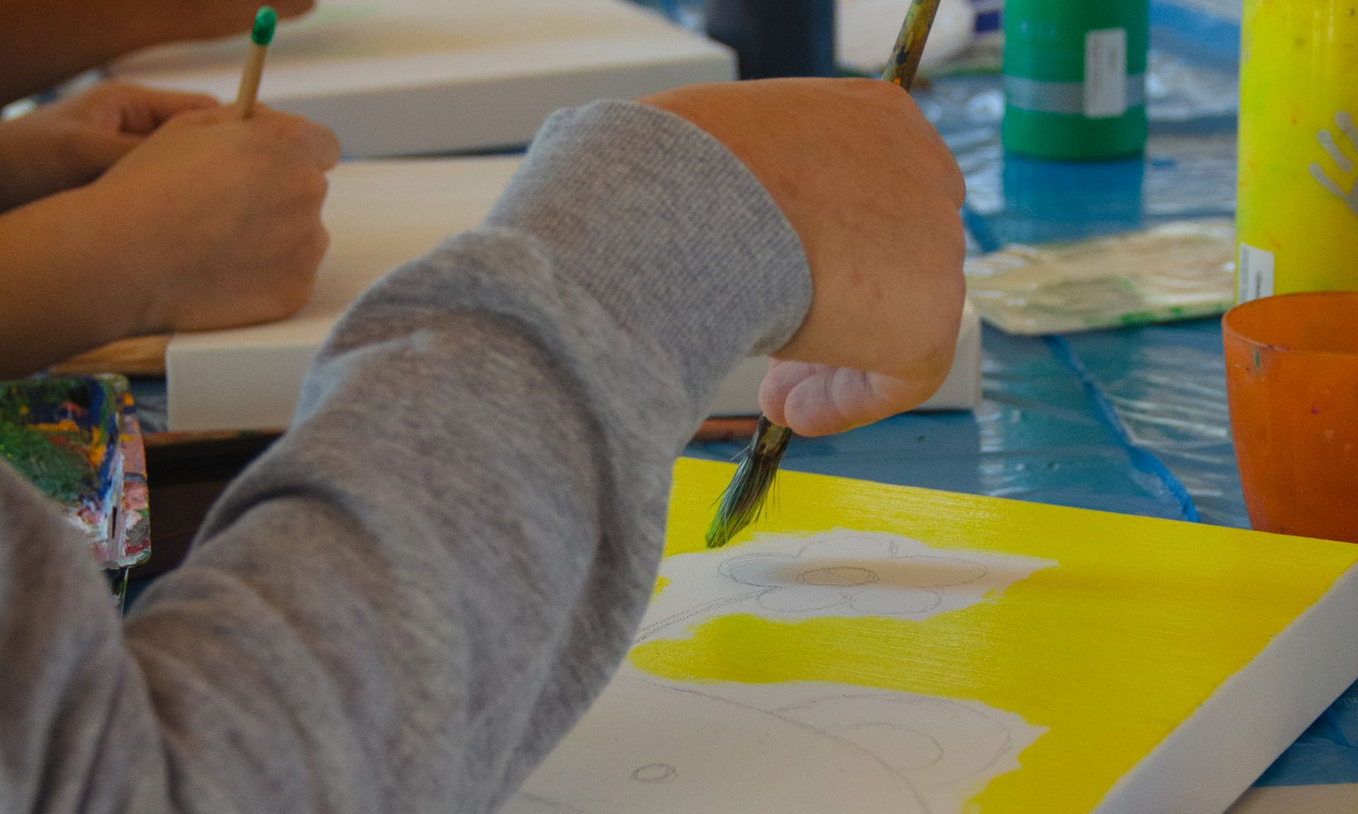 Kinder bemalen im Workshop Leinwände.