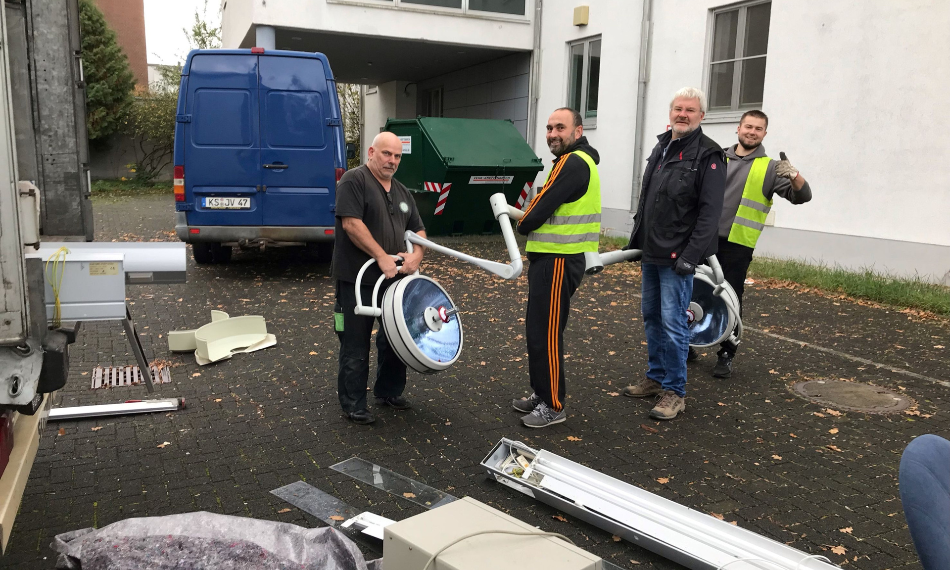 Vier Männer sortieren Material aus der Klinik