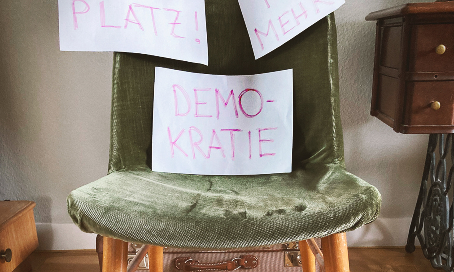 Stuhl mit drei Zetteln und der Aufschrift "Nimm Platz für mehr Demokratie"