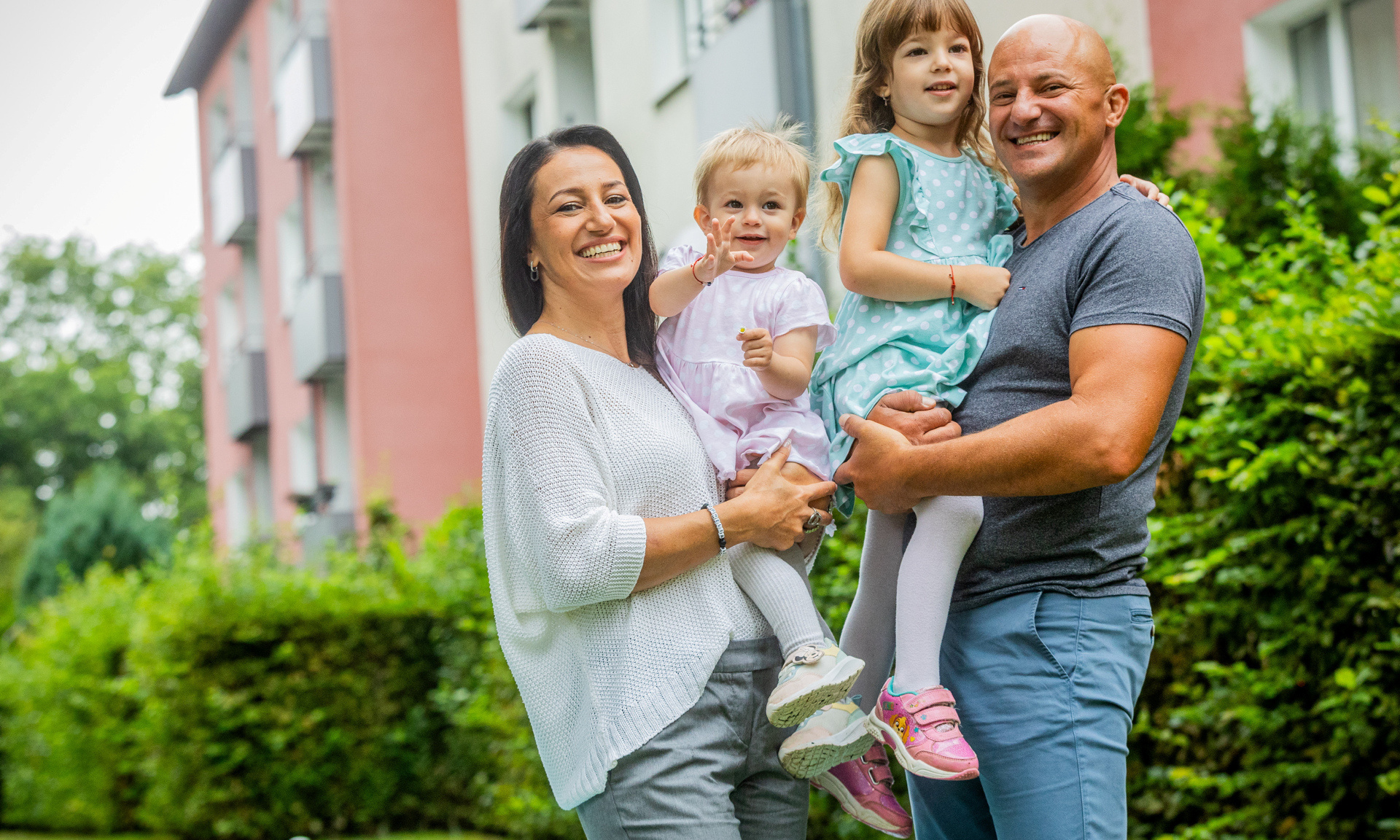 Familie steht vor einem Haus.