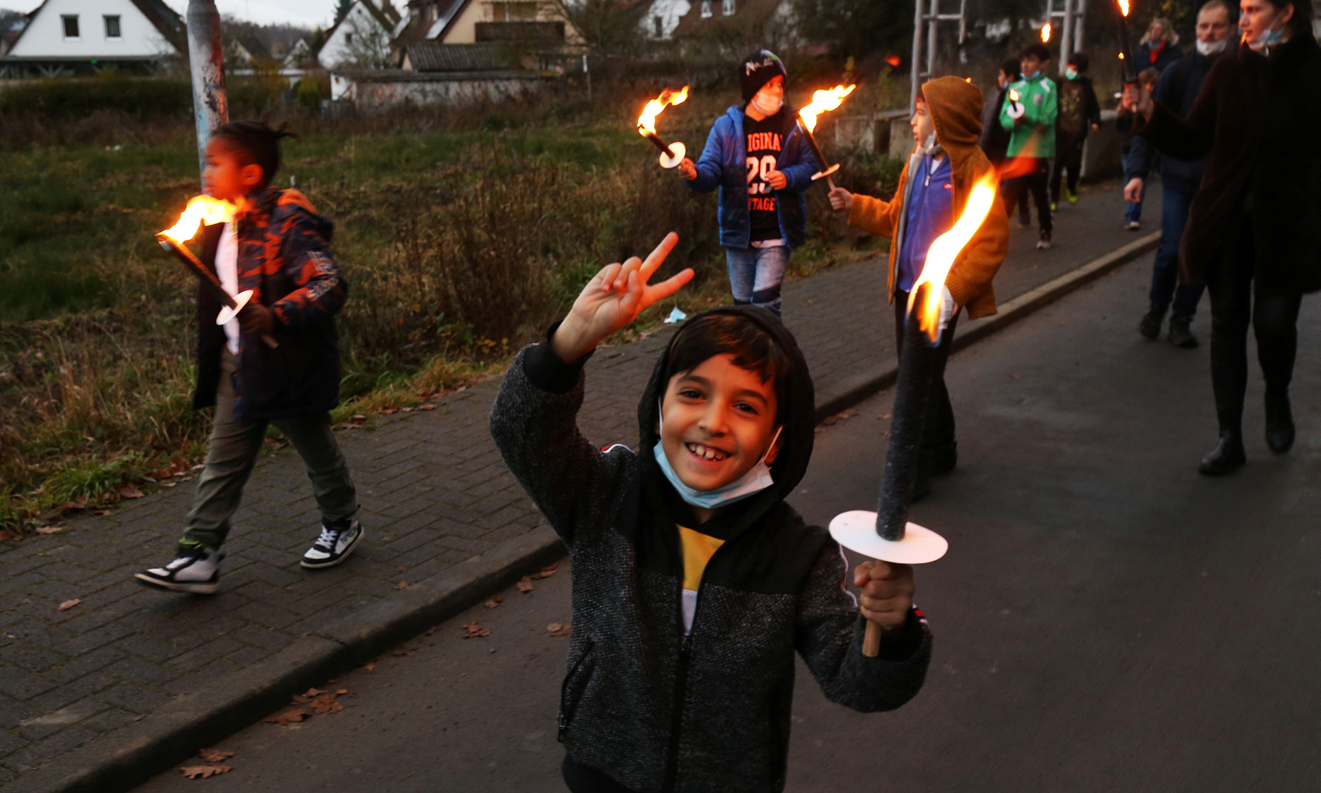 Kind mit Fackel schaut glücklich in die Kamera.