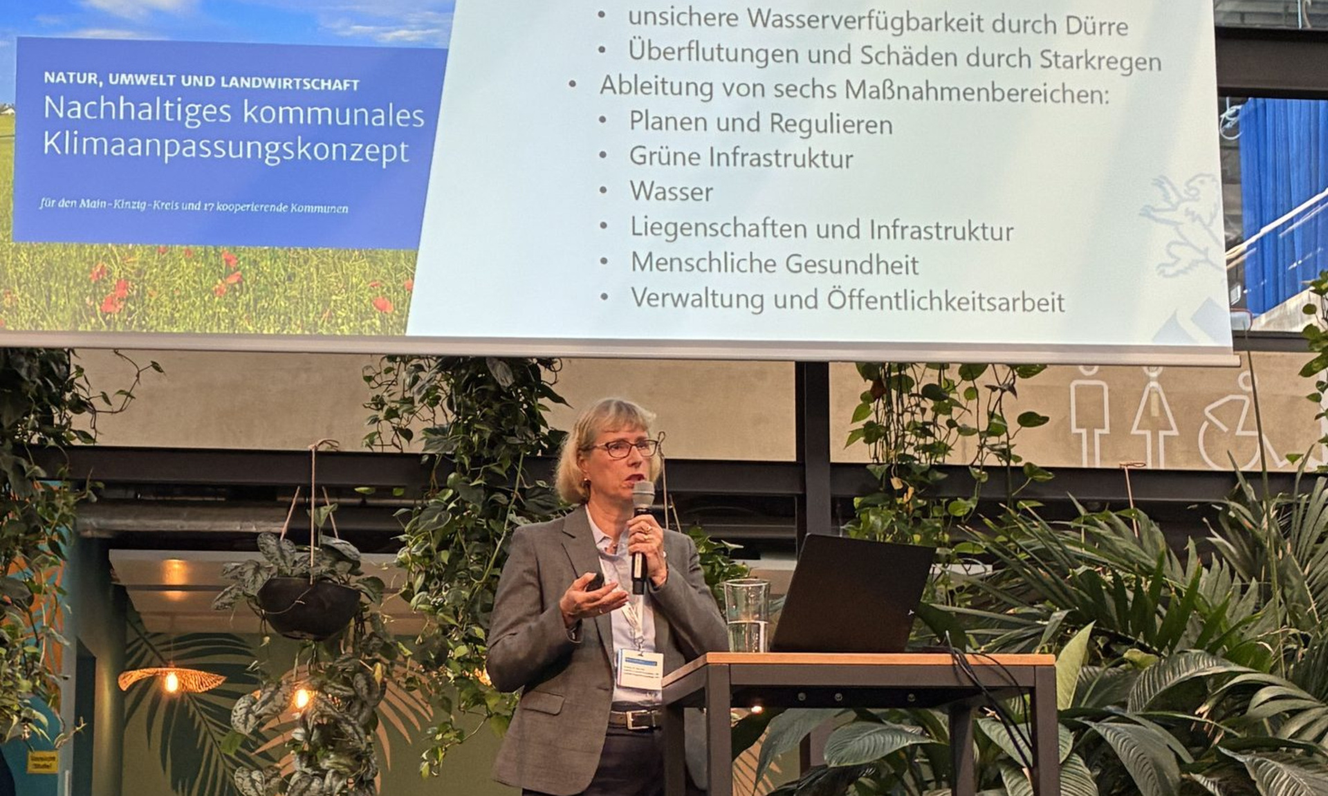 Monika Fontaine-Kretschmer, NHW-Geschäftsführerin und Sprecherin des Bundesverbands DIE STADTENTWICKLER, hält einen Vortrag mit Mikrofon in der Hand