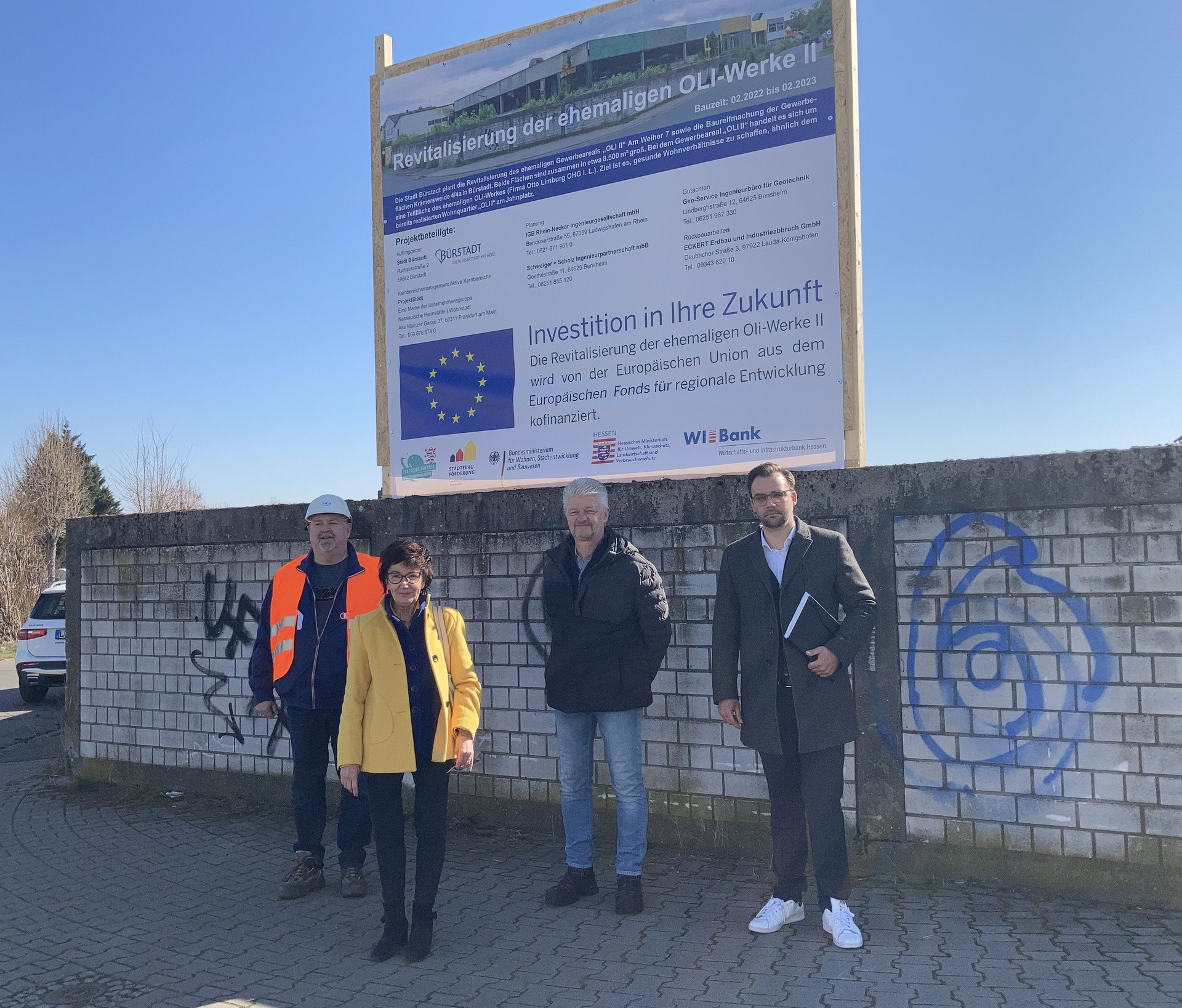 Vier Personen vor Bauschild in Bürstadt