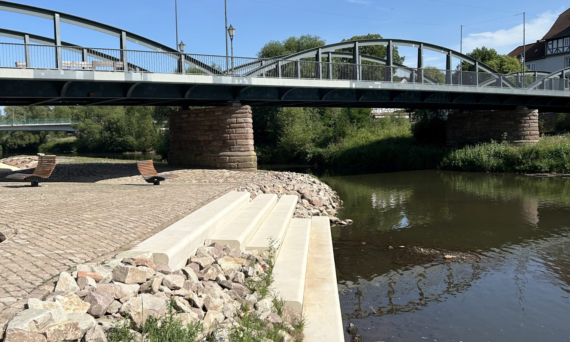 Anlegestelle zum Ein- und Aussteigen für Kanufahrer, rechts die Fulda, im Hintergrund eine Brücke