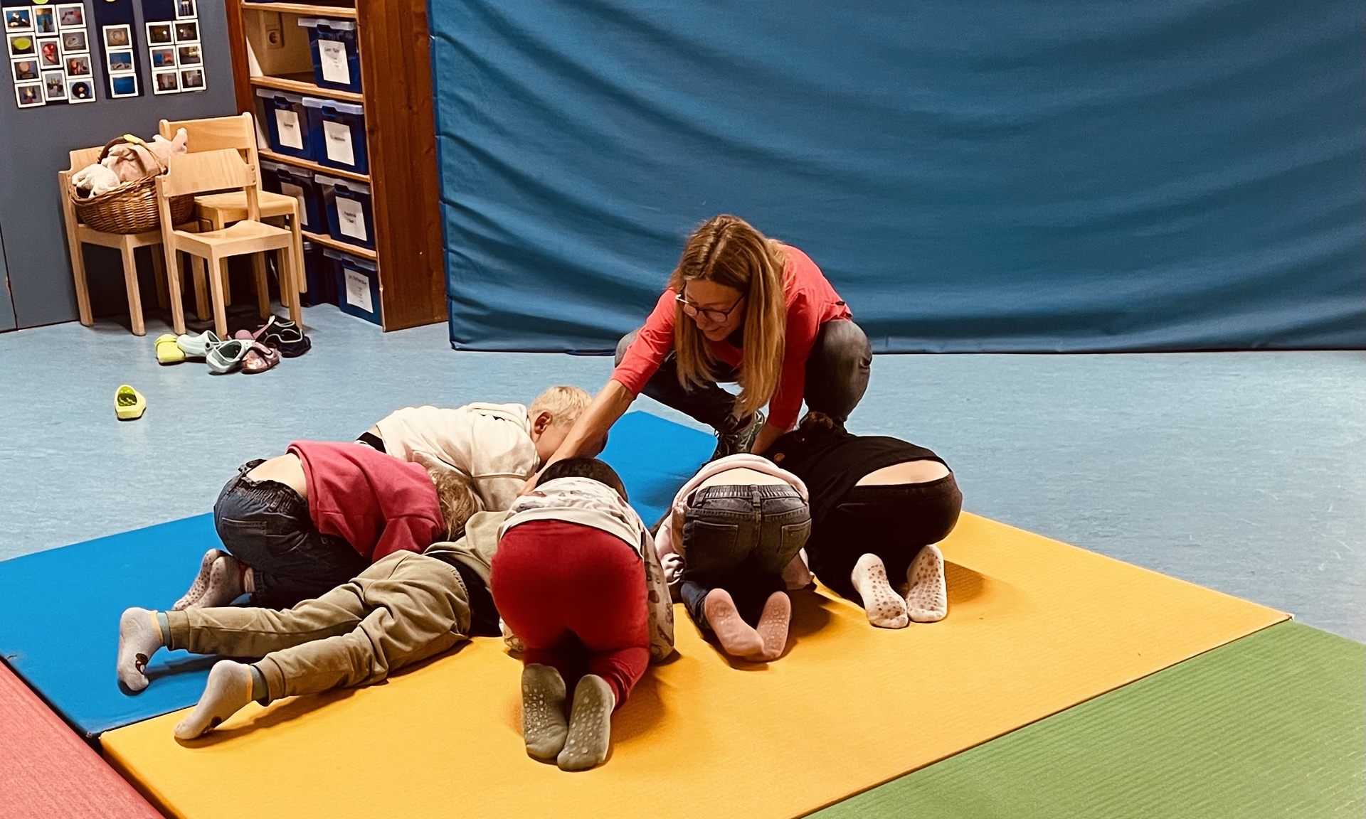 Kinder auf einer Turnmatte die Übungen machen