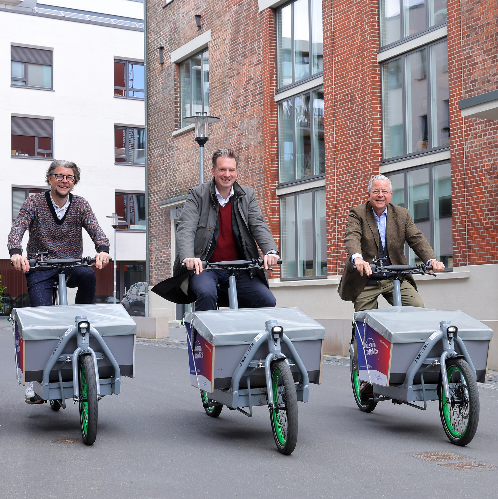Machen auf den neuen E-Lastenrädern eine Rundfahrt ums MartiniTor in Kassel: NHW-Geschäftsführer Dr. Constantin Westphal, Kassels Oberbürgermeister Dr. Sven Schoeller und sigo-Geschäftsführer Kai von Borck.