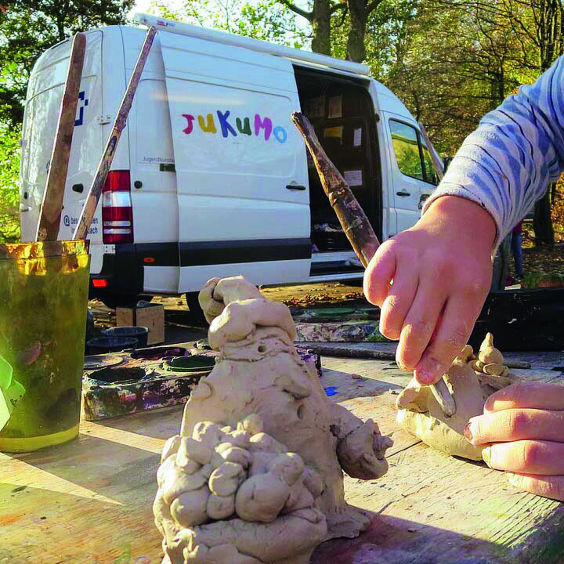 Im Hintergrund Sprinter-PKW und im Vordergrund Kind was bastelt