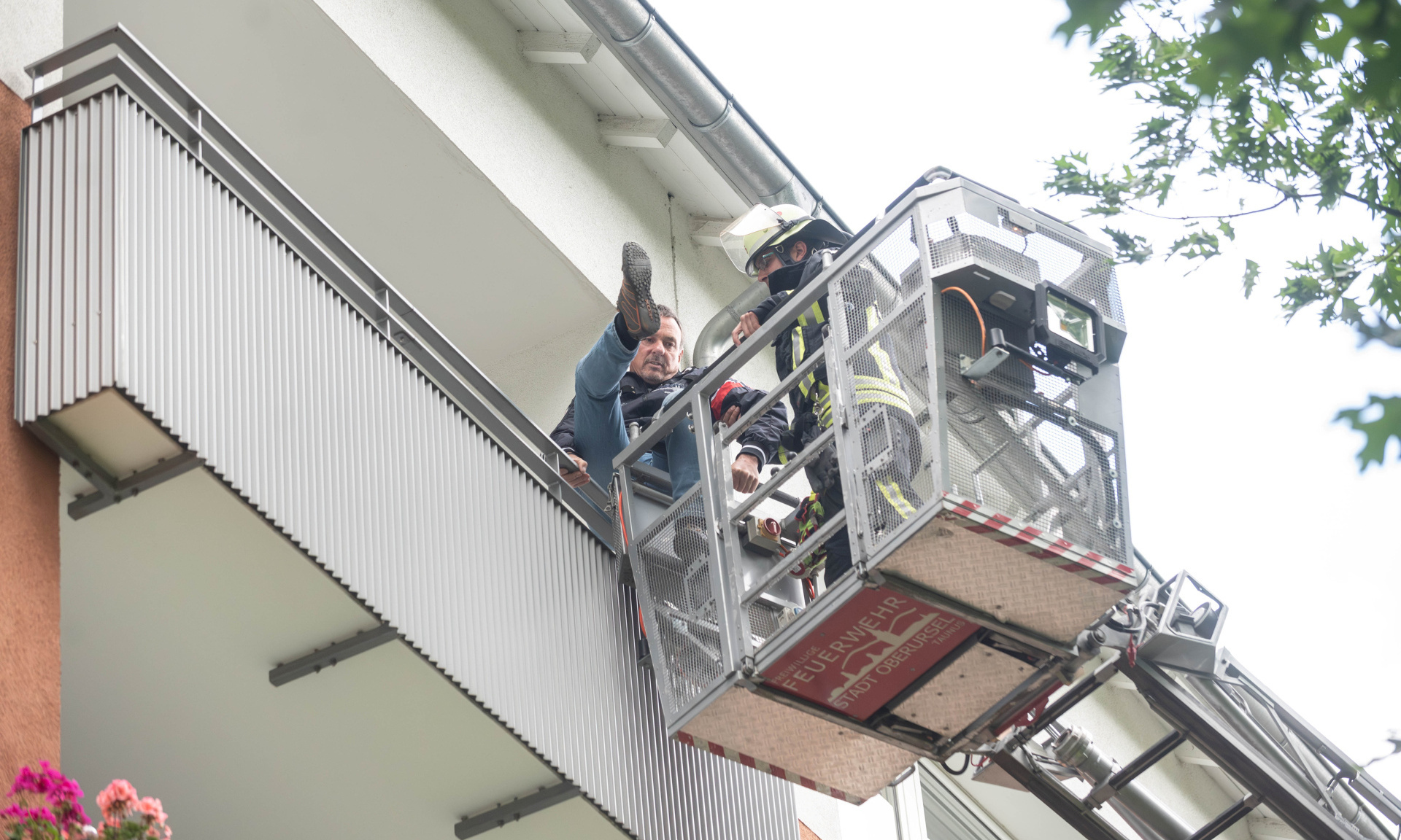 Eine Person wird mit Hilfe der Drehleiter vom Balkon gerettet