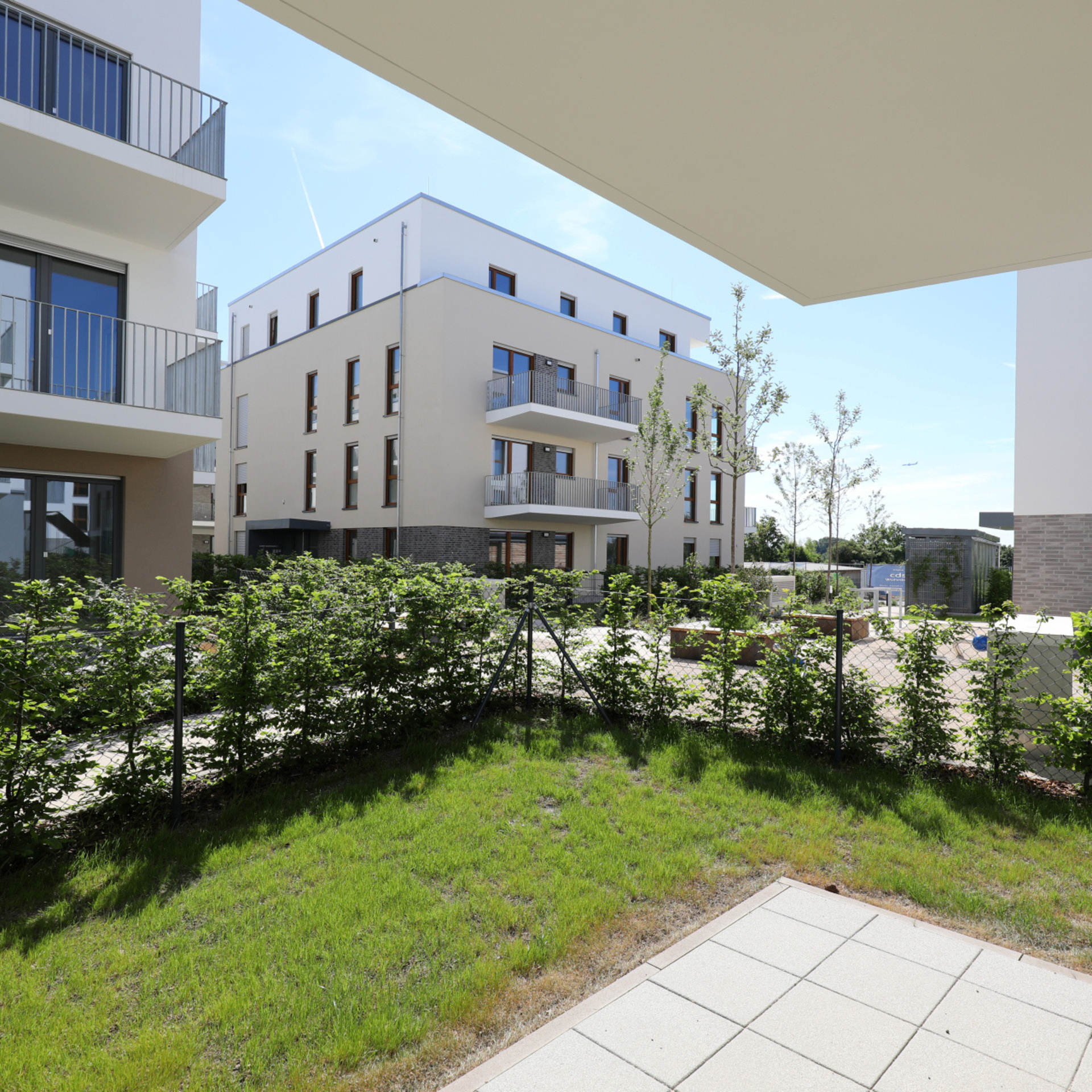 Blick von einer Terrasse in den Innenhof von einem Neubaugebiet.