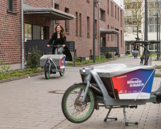 Frau fährt Lastenrad.