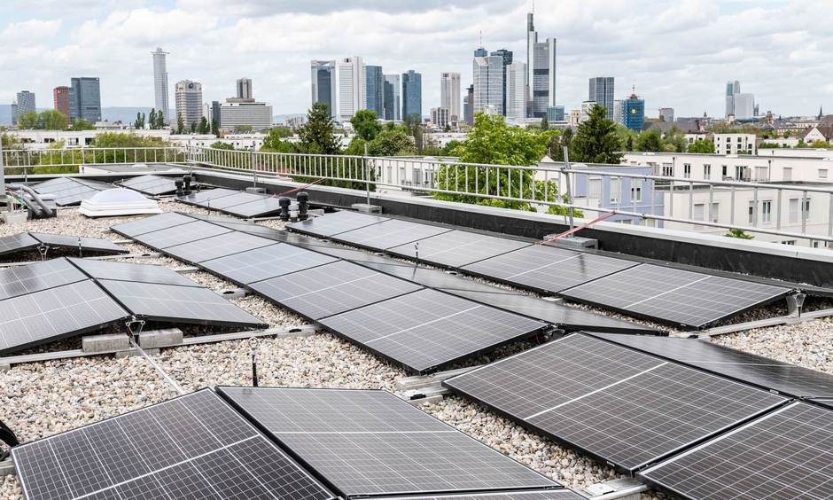 Photovoltaik-Anlagen auf den aufgestockten Dächern in der Fritz-Kissel-Siedlung. Im Hintergrund die Frankfurter Skyline.