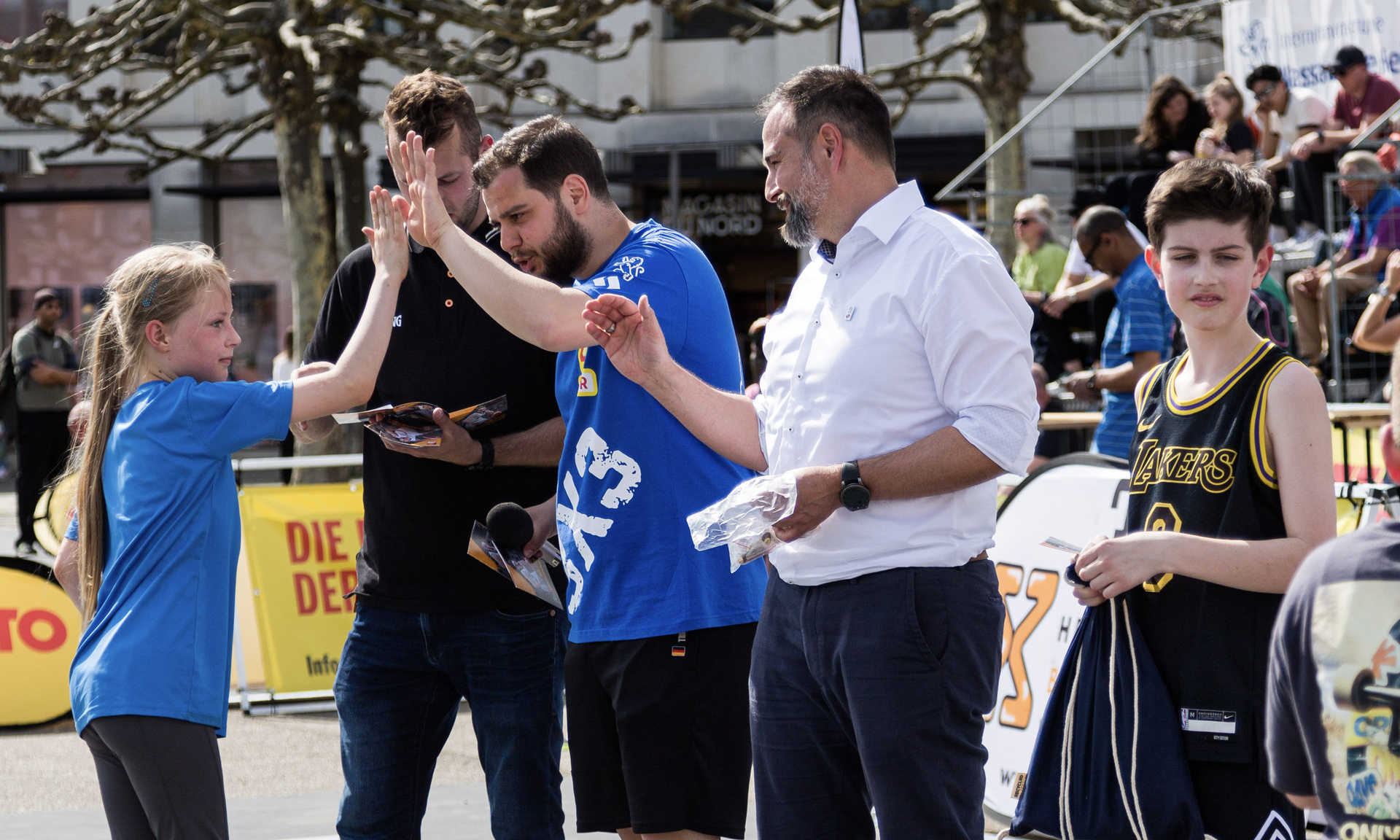Ein Kind gibt dem Trainer und Dirk Metzner ein High-Five