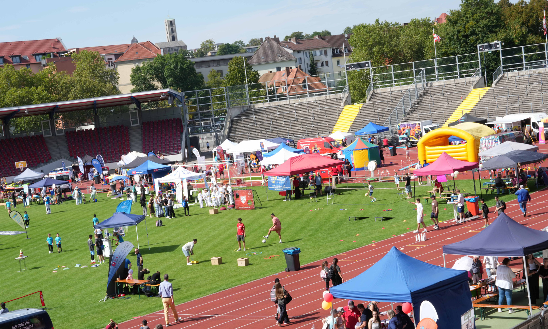 Kasseler Aue-Stadion mit vielen Menschen, Ständen und Pavillons