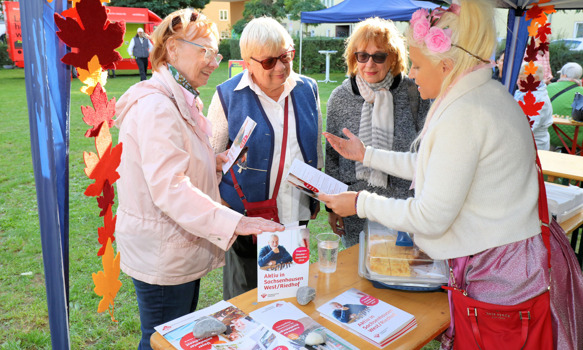 Drei ältere Damen lassen sich an einem Stand beraten