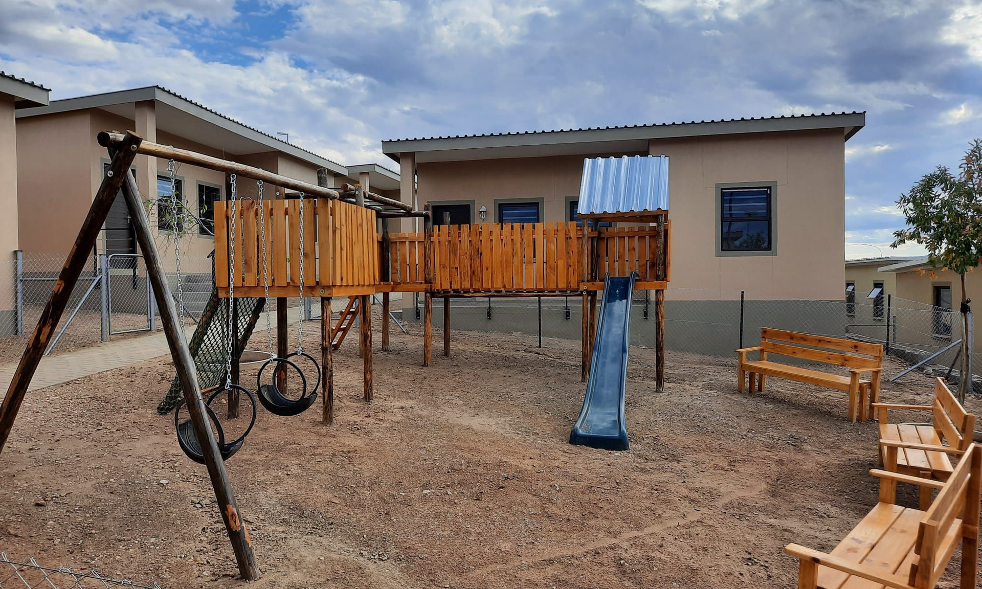 Kinderspielplatz und Sitzgelegenheiten vor den neuen Häusern