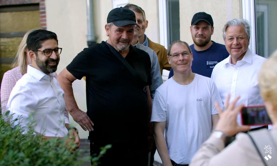 Der Minister steht mit den Bewohnern in einer Reihe und posiert für ein Foto.