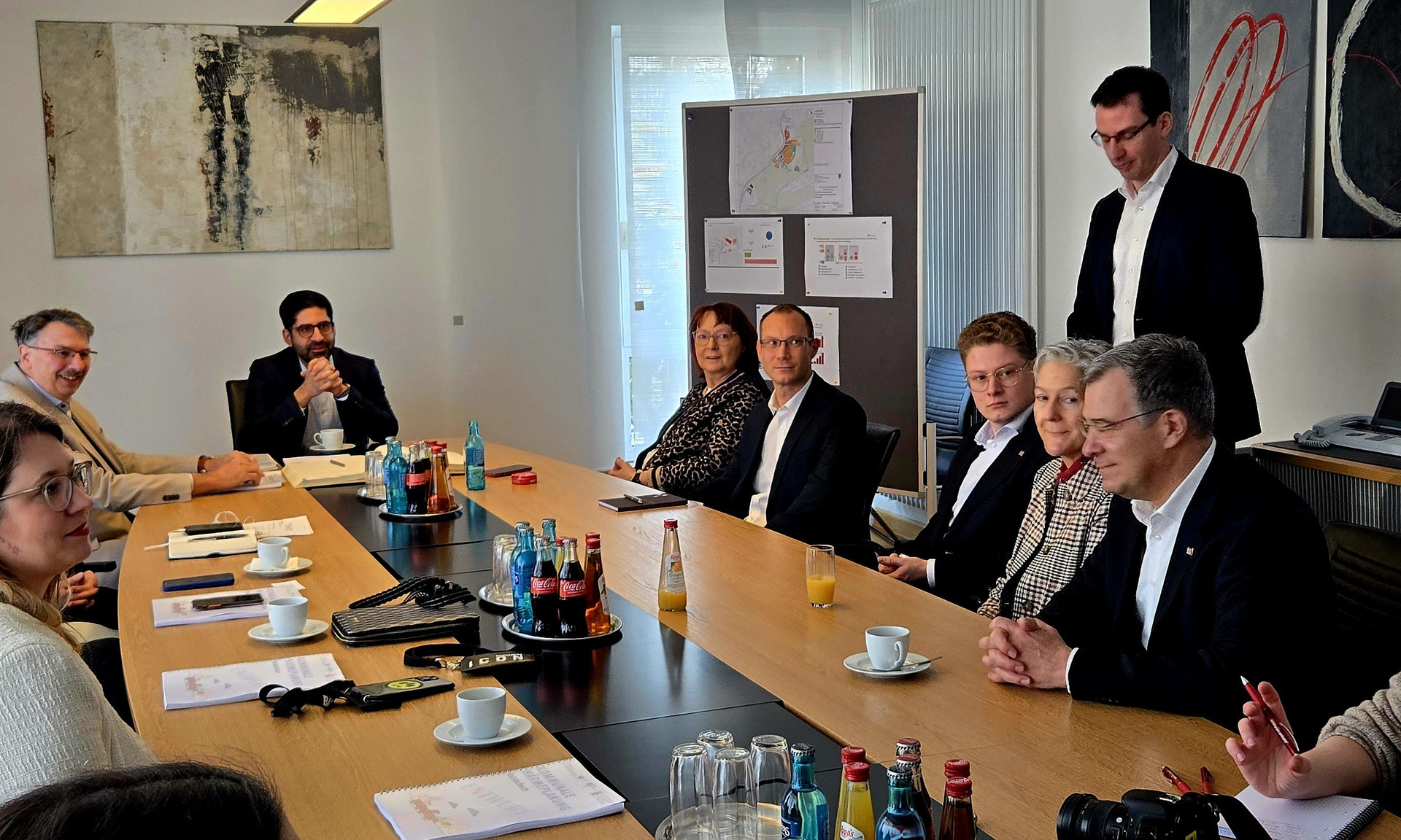 Eine Gruppe von Menschen sitzt an einem großen Tisch, einer davon ist Hessens Energieminister Kaweh Mansoori