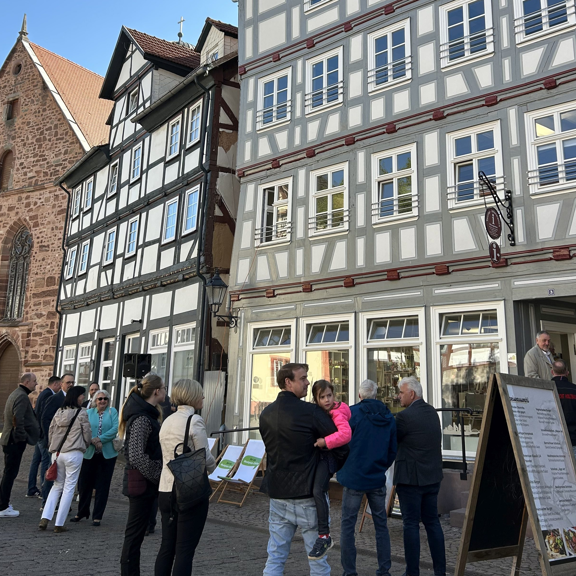 Mehrere Menschen vor einer schönen restaurierten Fachwerkkulisse in Rotenburg an der Fulda