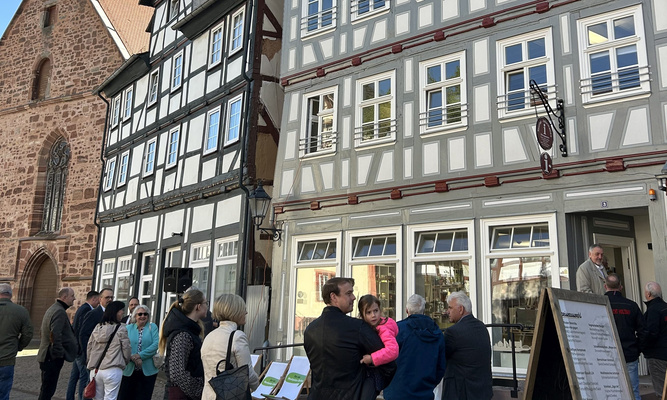 Mehrere Menschen vor einer schönen restaurierten Fachwerkkulisse in Rotenburg an der Fulda