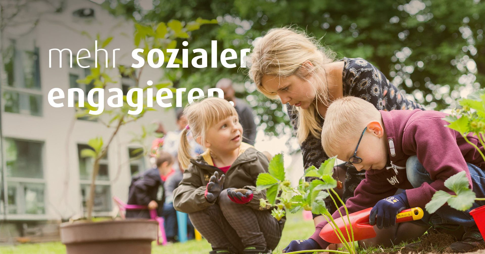Eine Frau pflanzt mit zwei Kindern Erdbeerpflanzen ein. Im Bild steht der Text "mehr sozialer engagieren".