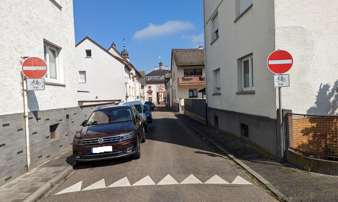 Auto in Straße und zwei Durchfahrt-Verboten-Schilder