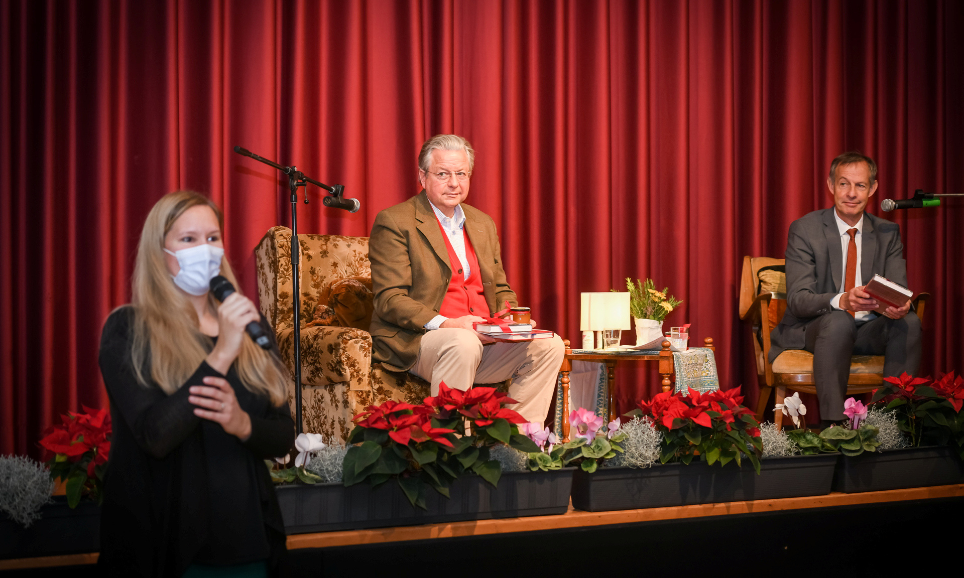 Die Moderatorin der Lesung steht vor der Bühne, im Hintergrund sind Dr. Westphal und OB Bausch.