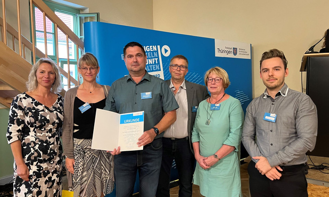 Übergabe der Urkunde für die Landgemeinde Nottertal-Heilinger Höhen: (v. li.) Ministerin Susanna Karawanskij, Sandy Harnisch (Mitarbeiterin Verwaltung), Sandro Seeländer (stellvertretender Bürgermeister), Marko Hesse (Vorsitzender Dorfentwicklungsbeirat), Claudia Görl (Mitarbeiterin Verwaltung) und Dominic Otto (Projektmitarbeiter ProjektStadt).