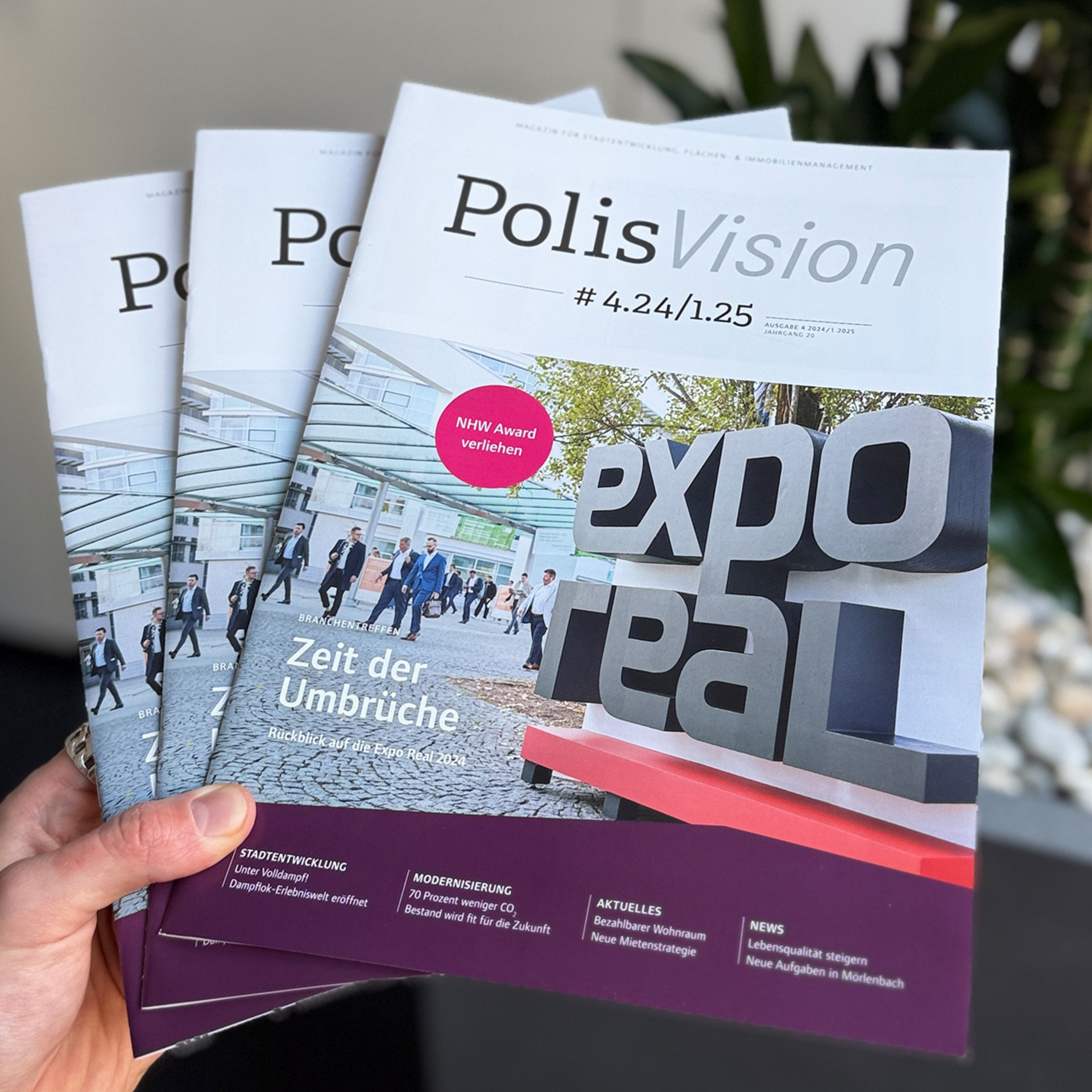 Drei gestaffelte PolisVision-Ausgaben vor einer Pflanze.