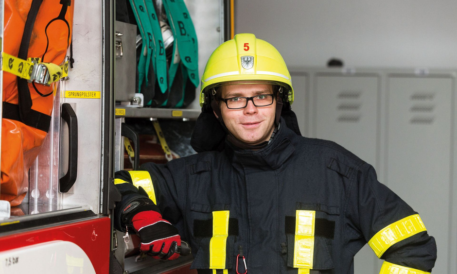 Feuerwehrmann steht am Feuerwehrfahrzeug