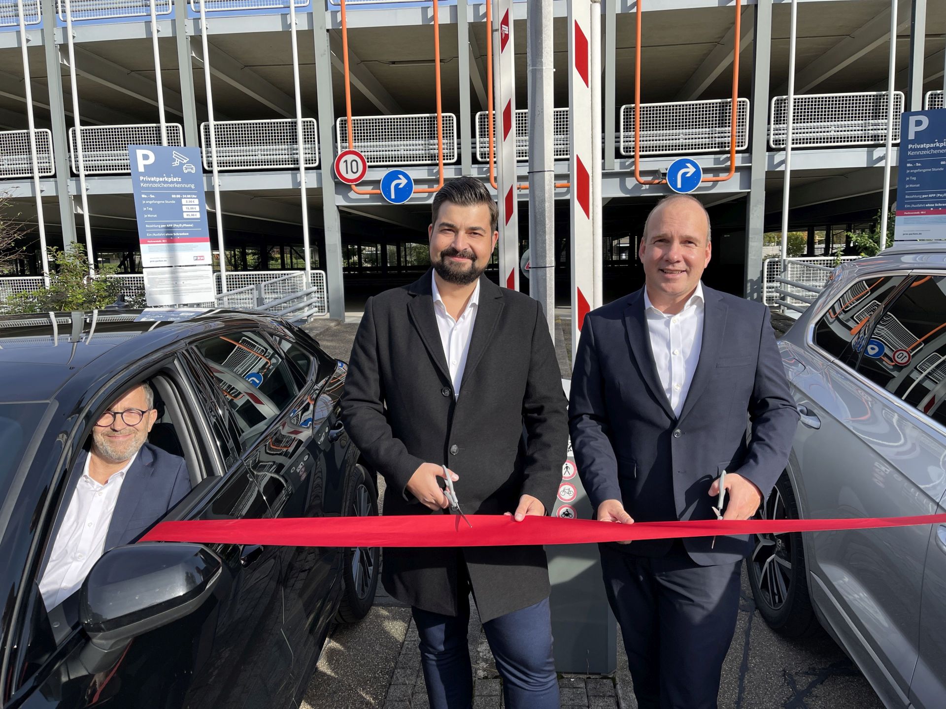 (v. li.) Robert Gasse (Head of Sales Park-Raum-Management PRM GmbH), Marko Guljelmovic (Geschäftsführer ParkRaum-Management PRM GmbH) und Holger Fuesser (Unternehmensgruppe Nassauische Heimstätte | Wohnstadt) eröffnen das Parkhaus, indem sie ein rotes Band durchschneiden