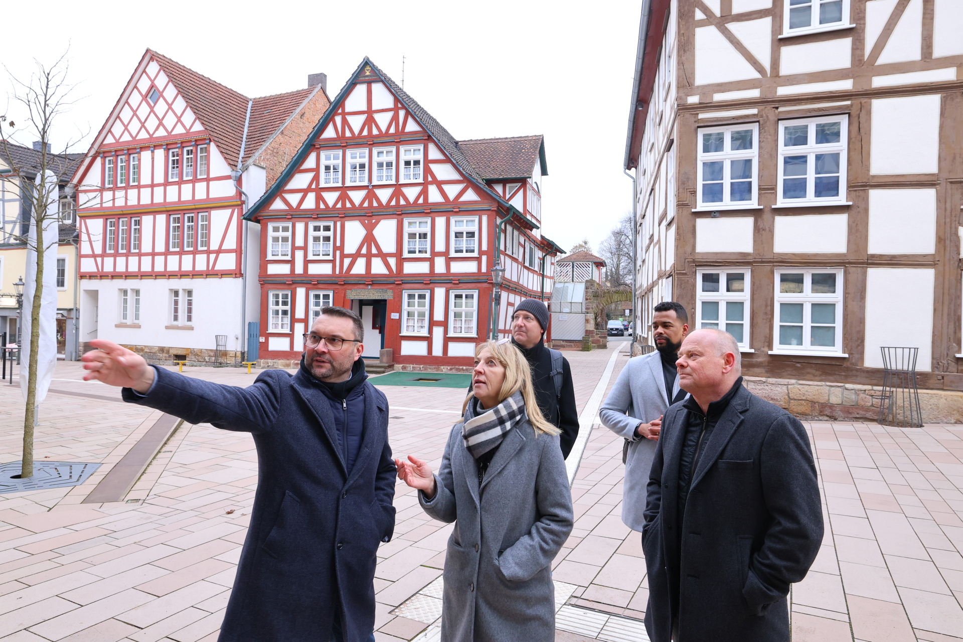 (v.li.) Hofgeismars Bürgermeister Torben Busse, Karin Jasch vom Hessischen Wirtschaftsministerium und Ulrich Türk, Leiter FB Stadtentwicklung Nord bei der ProjektStadt. Im Hintergrund Fachwerkhäuser.